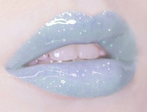 Close-up of a pair of shimmering, pastel-colored lips with glittery gloss.